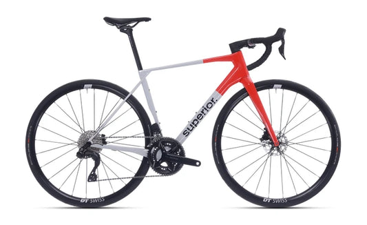 Velostudio Superior X-Road 9.5 GF racefiets met glanzende grijs-oranje afwerking, zichtbaar in de afbeelding.