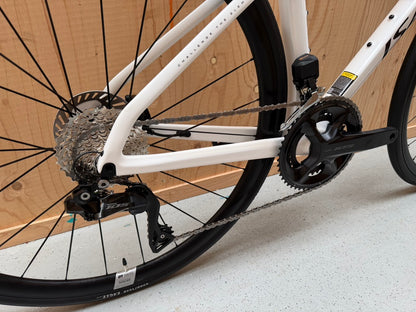 Zilveren Isaac Boson Mineral White 2026 S racefiets van Vélo Studio met aerodynamisch frame en racepositie op een weg.