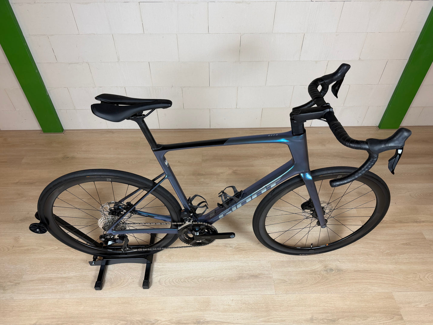 Giant Defy Advanced 0 racefiets in zwart en blauw, zichtbaar met aerodynamisch frame en geavanceerde wielenset.