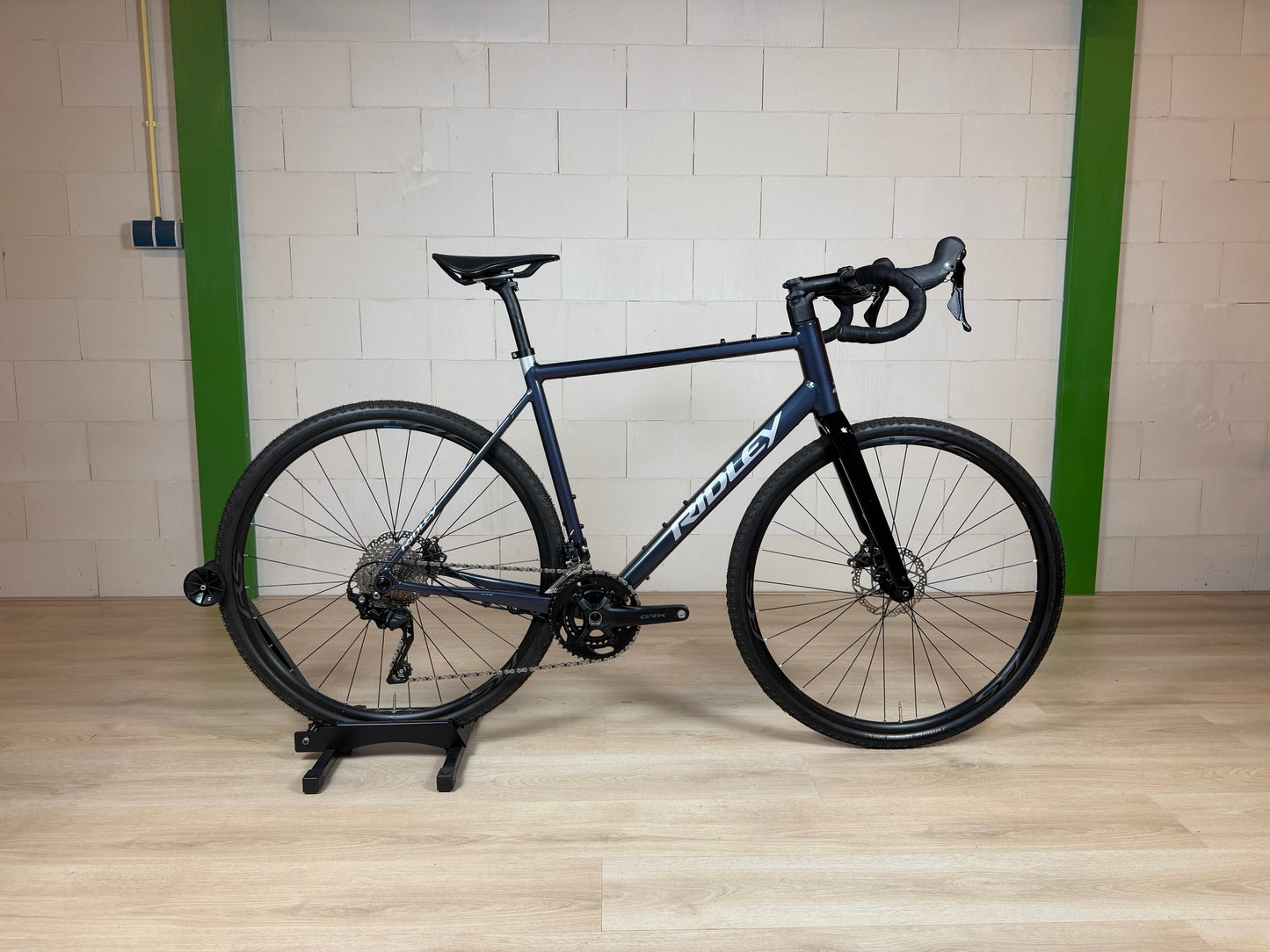 Ridley Grifn A racefiets van Vélo Studio, zwart met blauwe accenten, frame en racewielen zichtbaar op de foto.