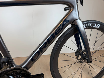 Orbea Orca M10iLTD PWR racefiets met aerodynamisch frame en geavanceerde onderdelen, zwart met blauwe accenten, zichtbaar in de afbeelding