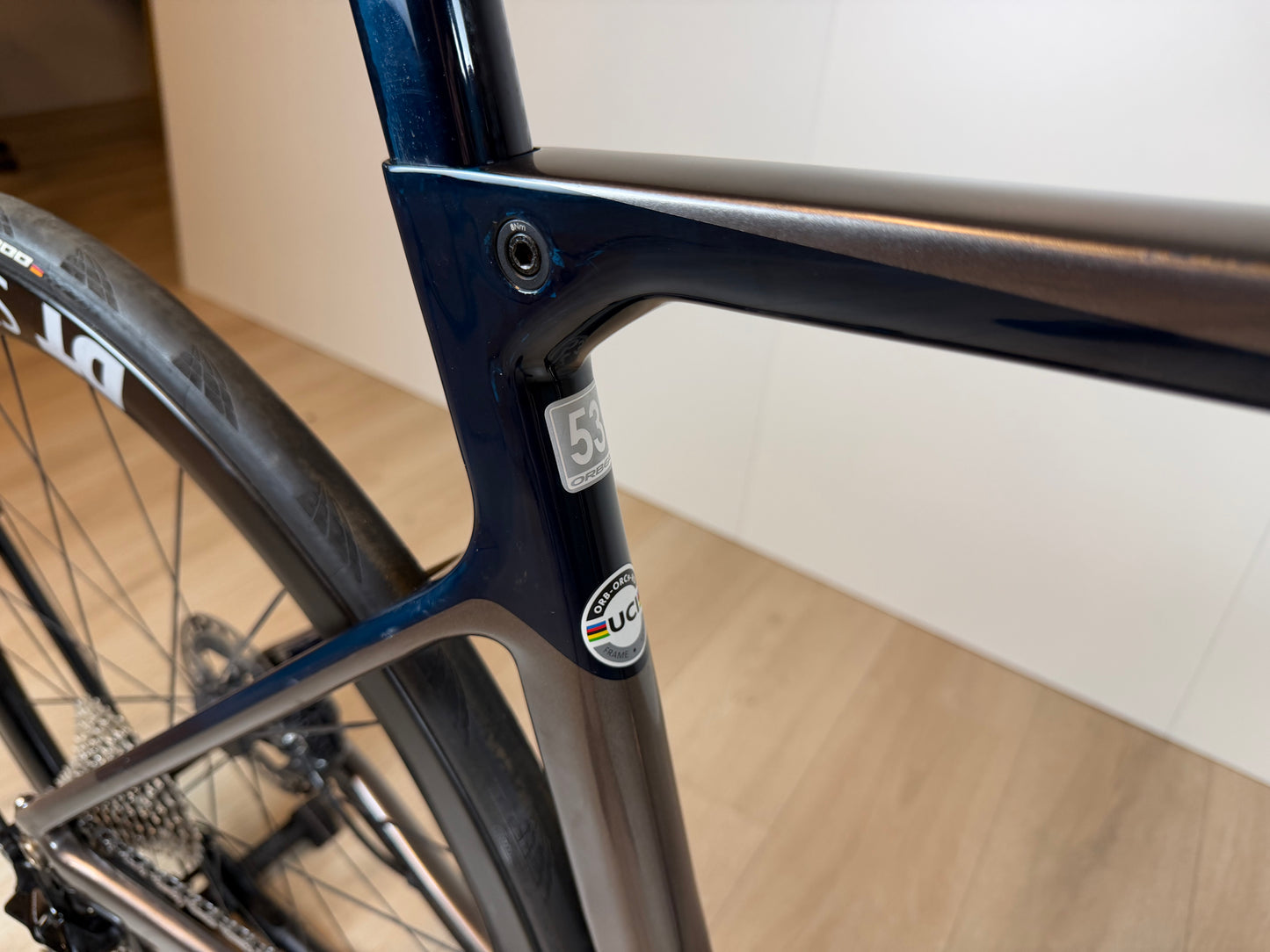Fietsbeeld van een Orbea Orca M10iLTD PWR racefiets met carbon frame en aerodynamisch ontwerp, geplaatst op een weg.