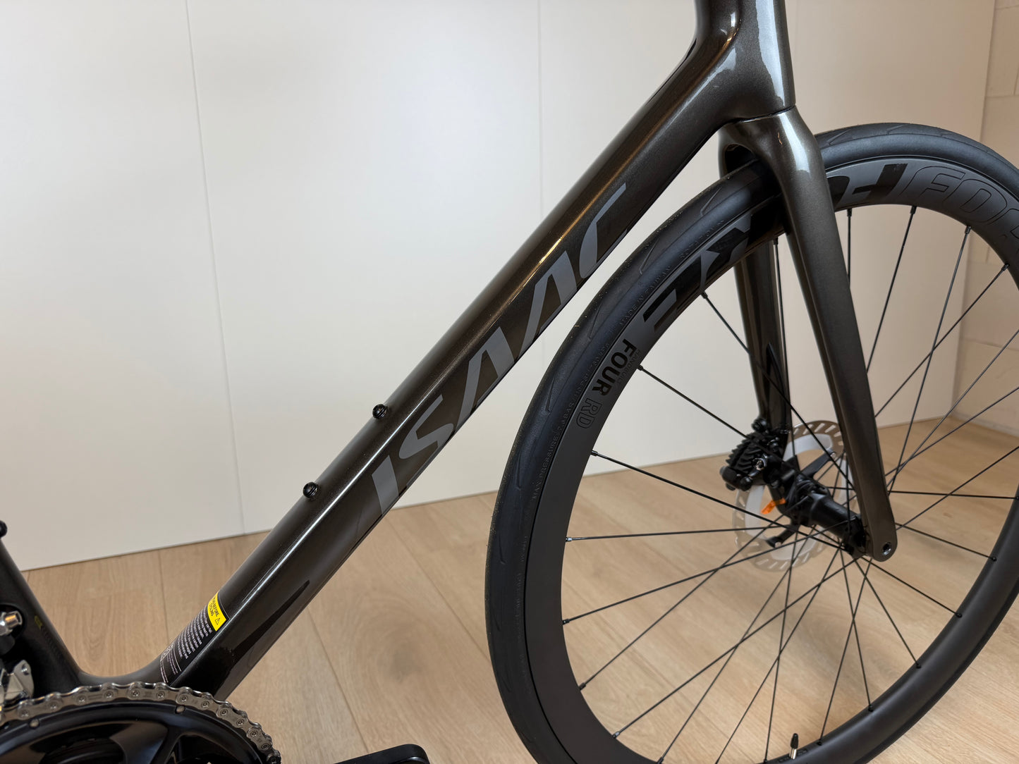 Zilveren Isaac Boson Sonic 2026 racefiets van Vélo Studio, frame en wielen zichtbaar op de afbeelding