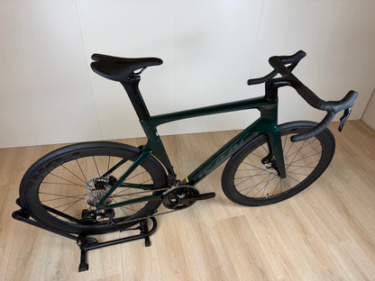 Groene Isaac Meson L racefiets van Vélo Studio met aerodynamisch frame en racewielen, klaar voor snelheid en prestaties.