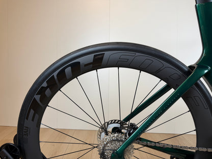 Groene Isaac Meson XL racefiets van Vélo Studio met aerodynamisch frame en racewielen, klaar voor snelle ritten.