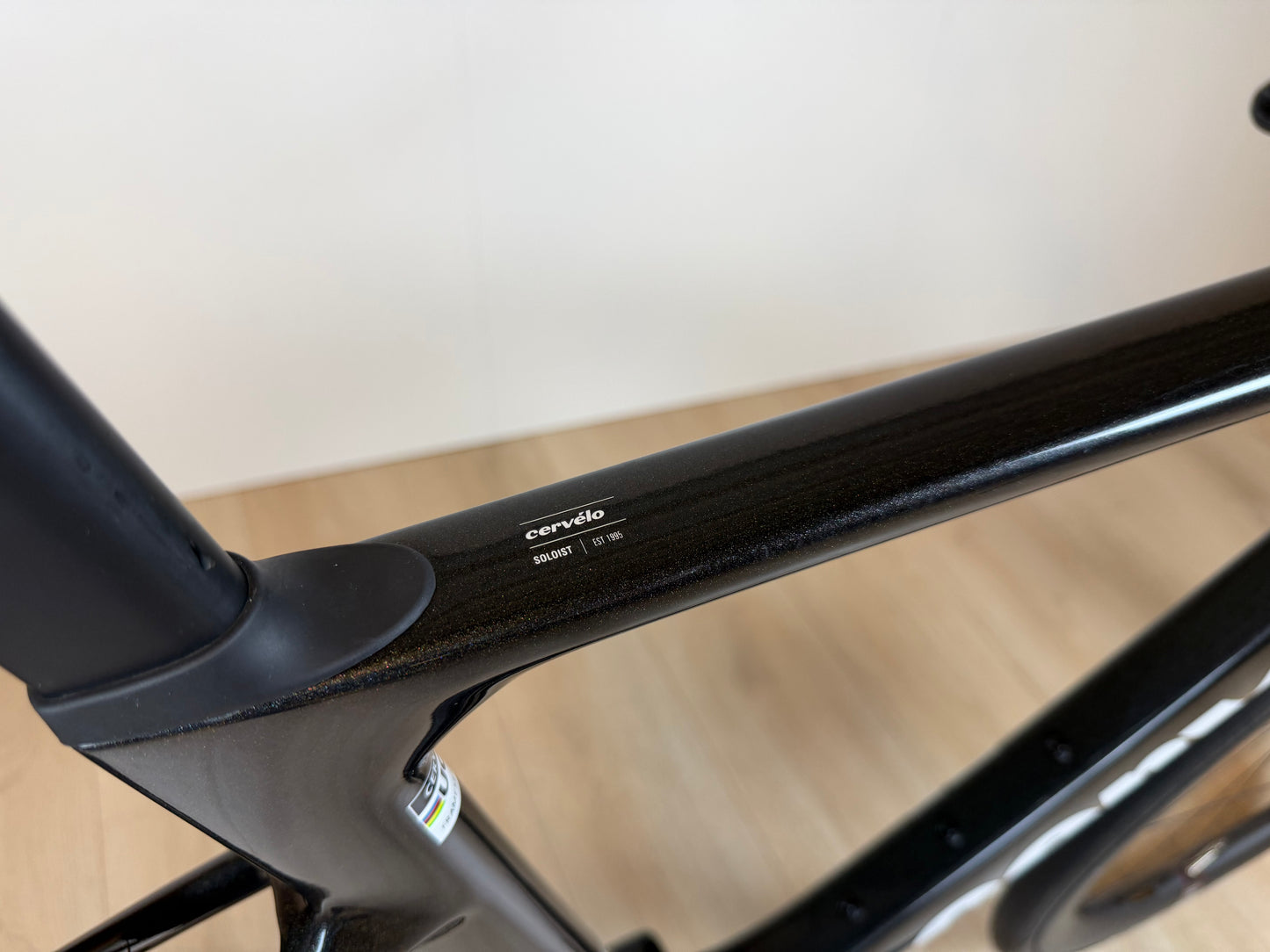 Cervélo Soloist racefiets frame in zwart met merknaam, gelegen op houten vloer, door Vélo Studio.