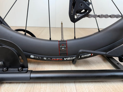 Cervélo Soloist racefiets frame in zwart met rode accenten, op een houten vloer, door Vélo Studio.