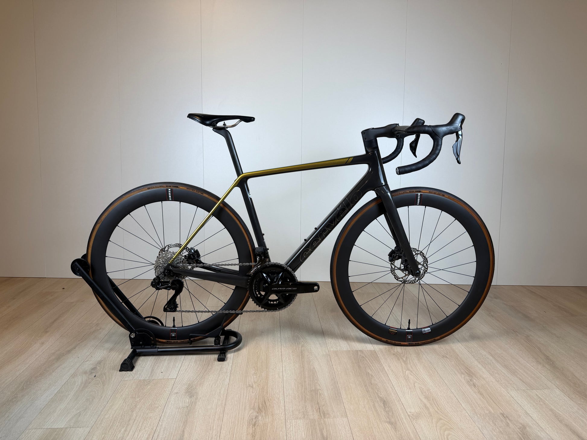 Racefiets Cervelo R5 Dura-Ace Di2 met aerodynamisch frame en elektronische schakeling, zwart met rode accenten, op een weg.