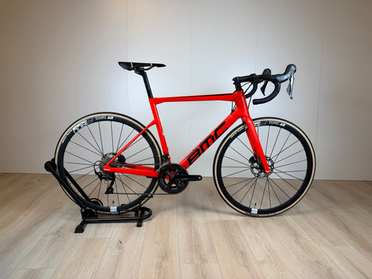 Zwart BMC Teammachine SLR FIVE racefiets met aerodynamisch frame en lichte carbon wielen, gestald op een weg.