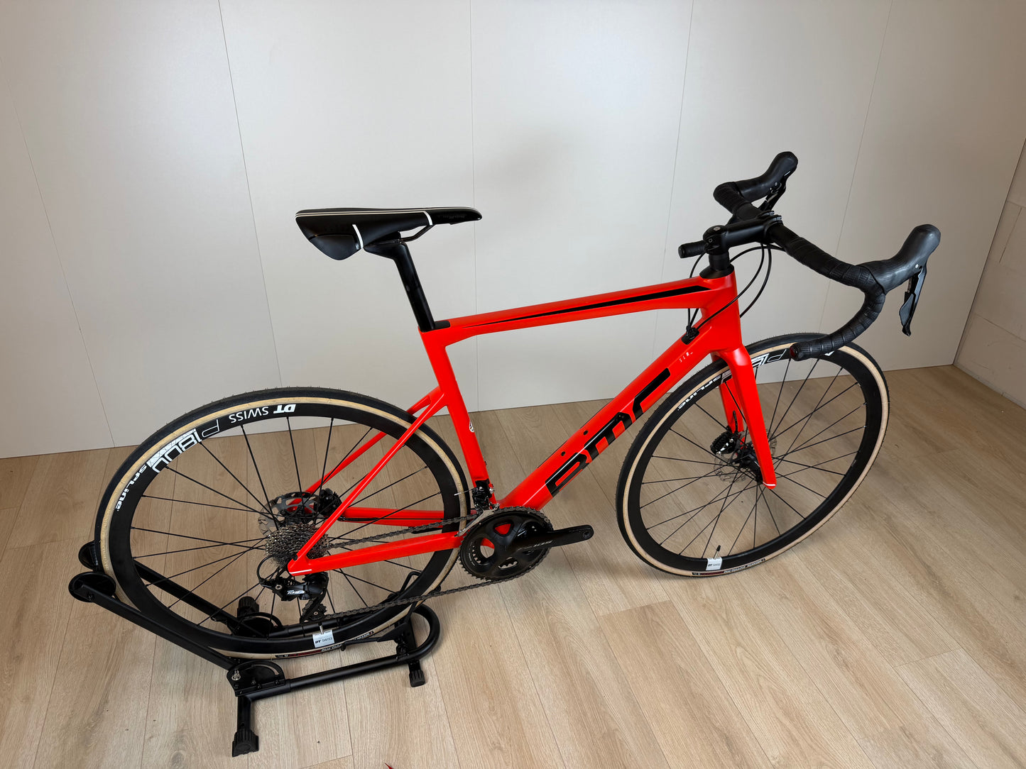 Lichte BMC Teammachine SLR FIVE racefiets met aerodynamisch frame en zwart-witte kleurstelling, klaar voor wielerwedstrijden