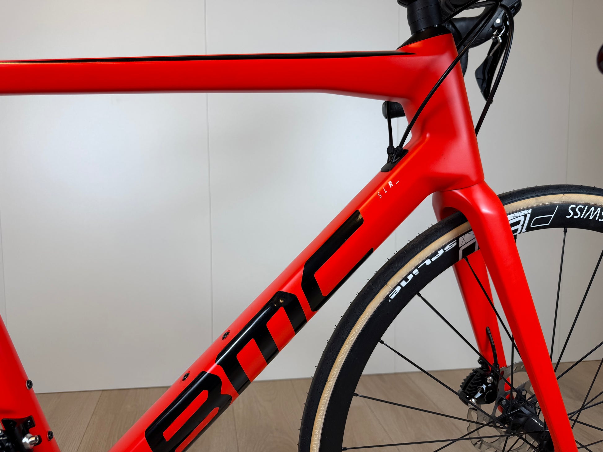 Fiets BMC Teammachine SLR FIVE in zwart en rood, ligfiets met aerodynamisch frame en geavanceerde onderdelen, klaar voor racegebruik.
