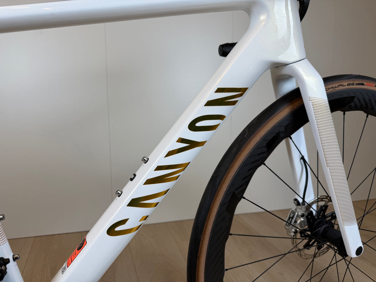 Fietsfoto van de Canyon Endurace CFR racefiets met zwart-witte frame en aerodynamische onderdelen, geschikt voor lange ritten.