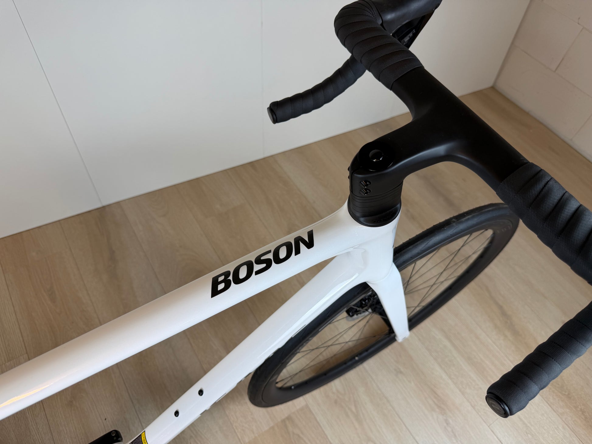 Witte Isaac Boson Mineral Racefiets van Vélo Studio met slanke frame en racegerichte onderdelen, zichtbaar in de afbeelding.
