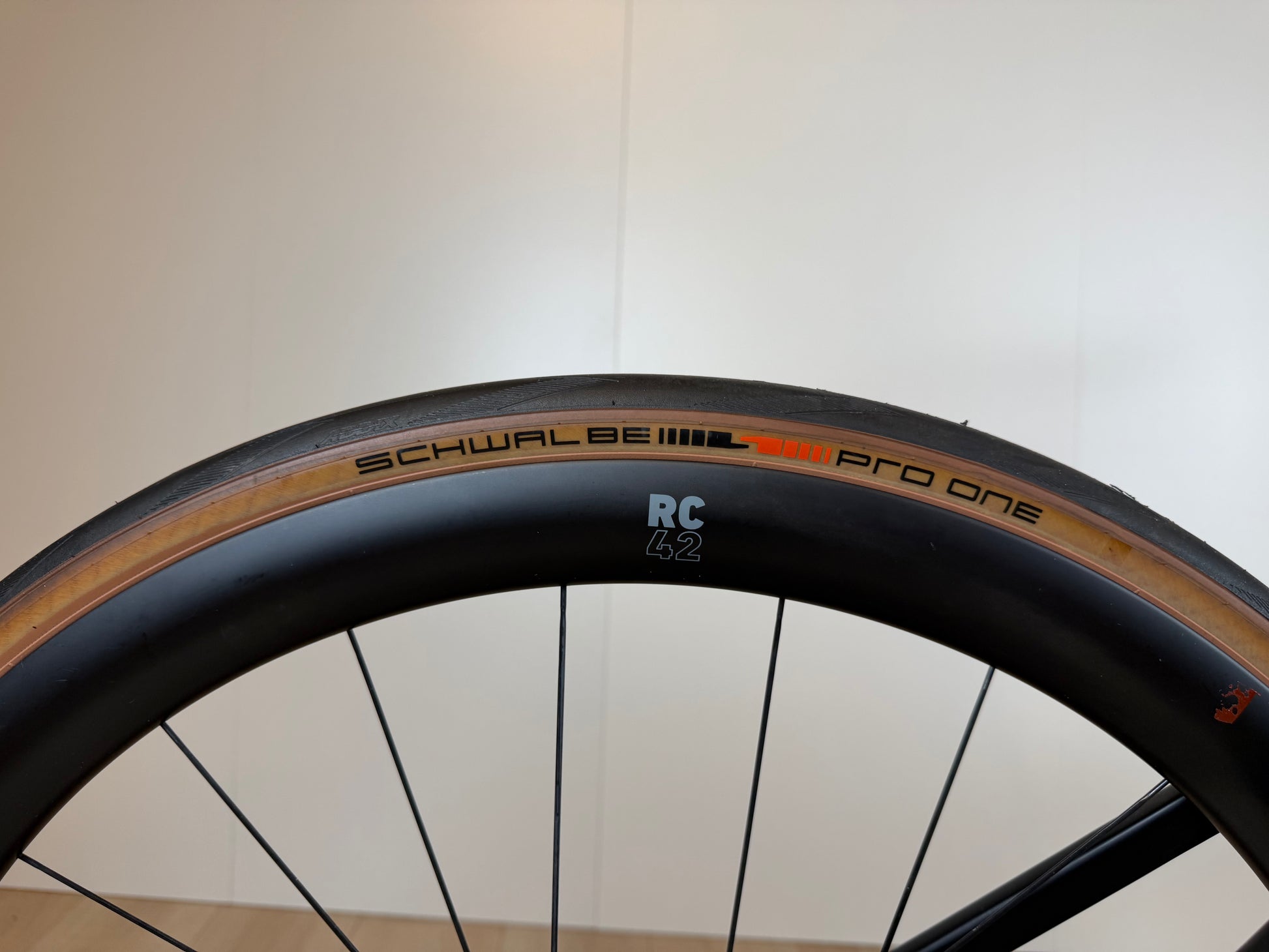 Rode Reveal 06 fiets van Vélo Studio, close-up van het frame en wiel met gedetailleerde afwerking en unieke ontwerpdetails