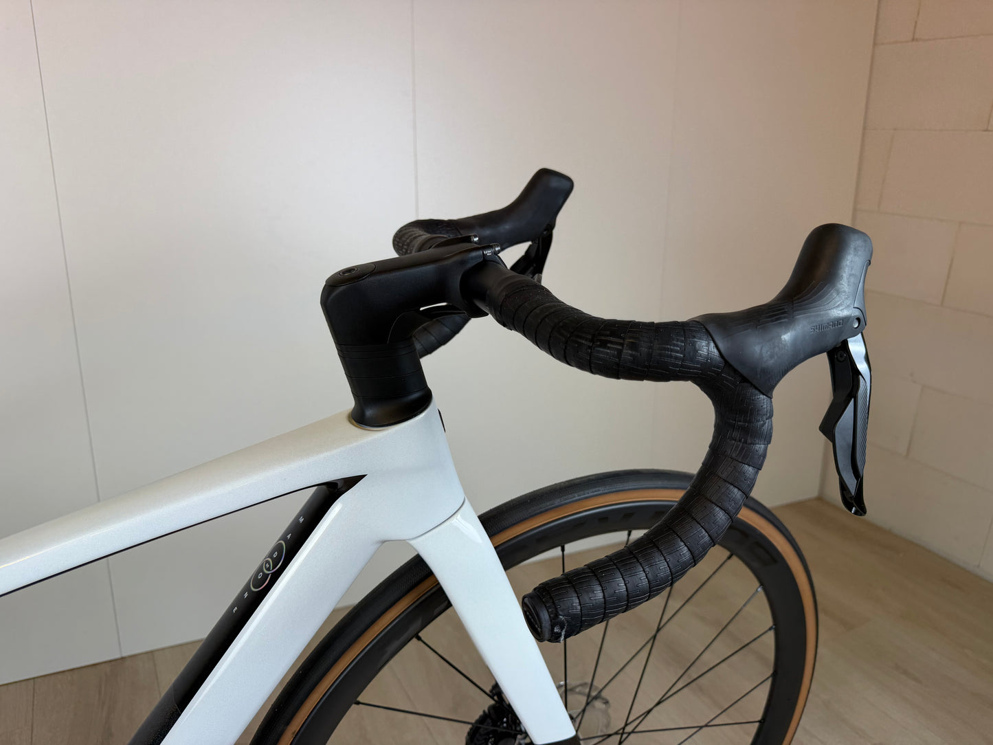 Fietsfoto van een Trek Madone SL 6 Gen 8 racefiets met aerodynamisch frame en geavanceerde wielset, zichtbaar in een lichte omgeving.