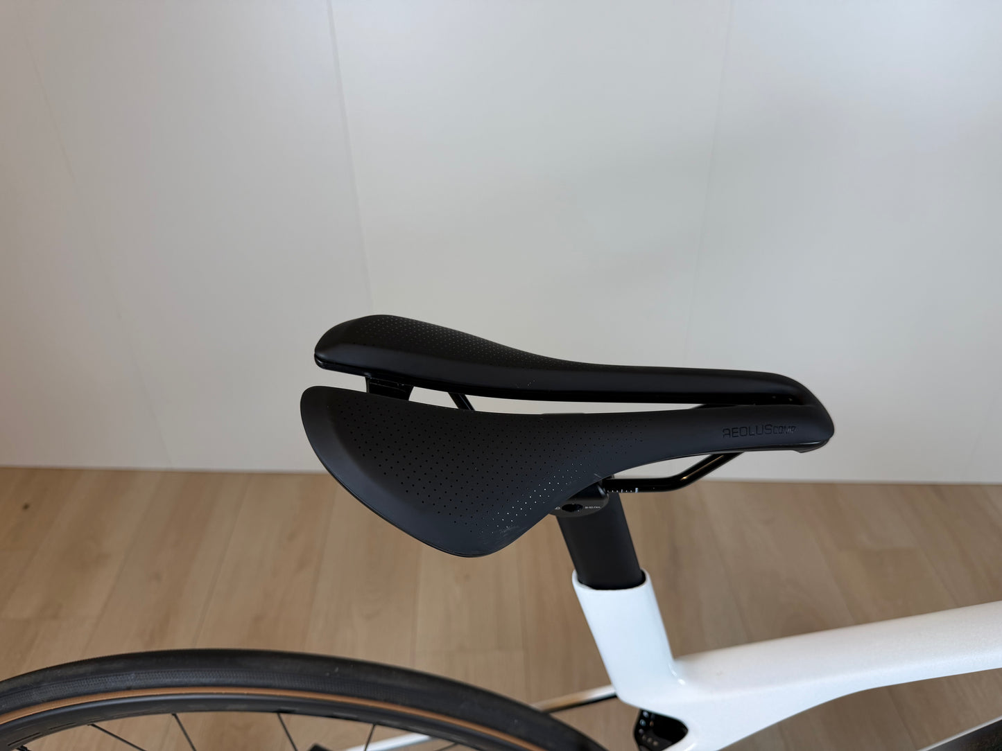 Fiets Trek Madone SL 6 Gen 8 racefiets met aerodynamisch frame en dunne banden, gelegen op een racebaan.