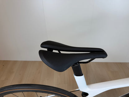 Fiets Trek Madone SL 6 Gen 8 racefiets met aerodynamisch frame en dunne banden, gelegen op een racebaan.