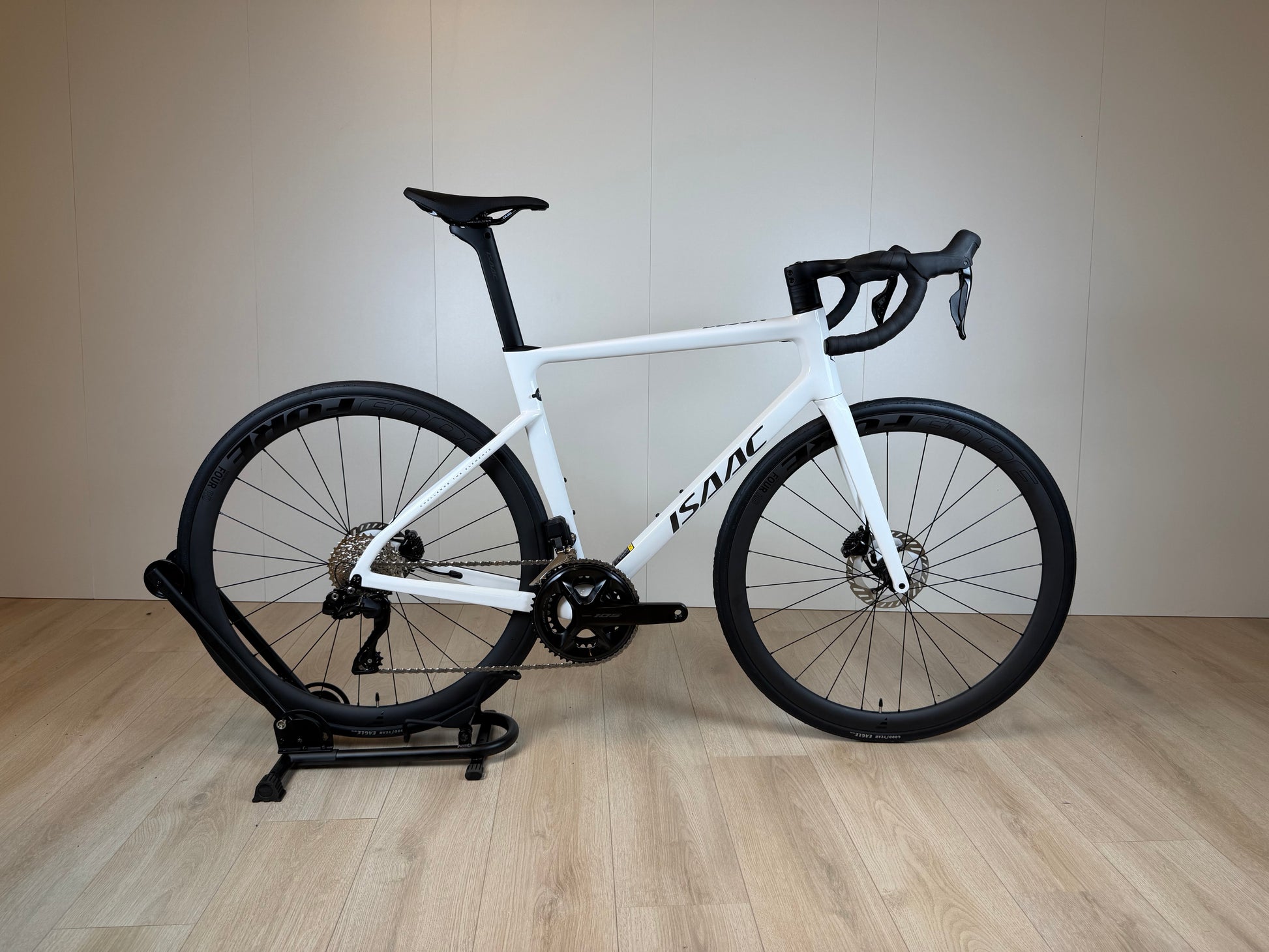 Wit racefiets Isaac Boson Mineral White 2026 M van Vélo Studio, close-up van frame en onderdelen op een racebaan