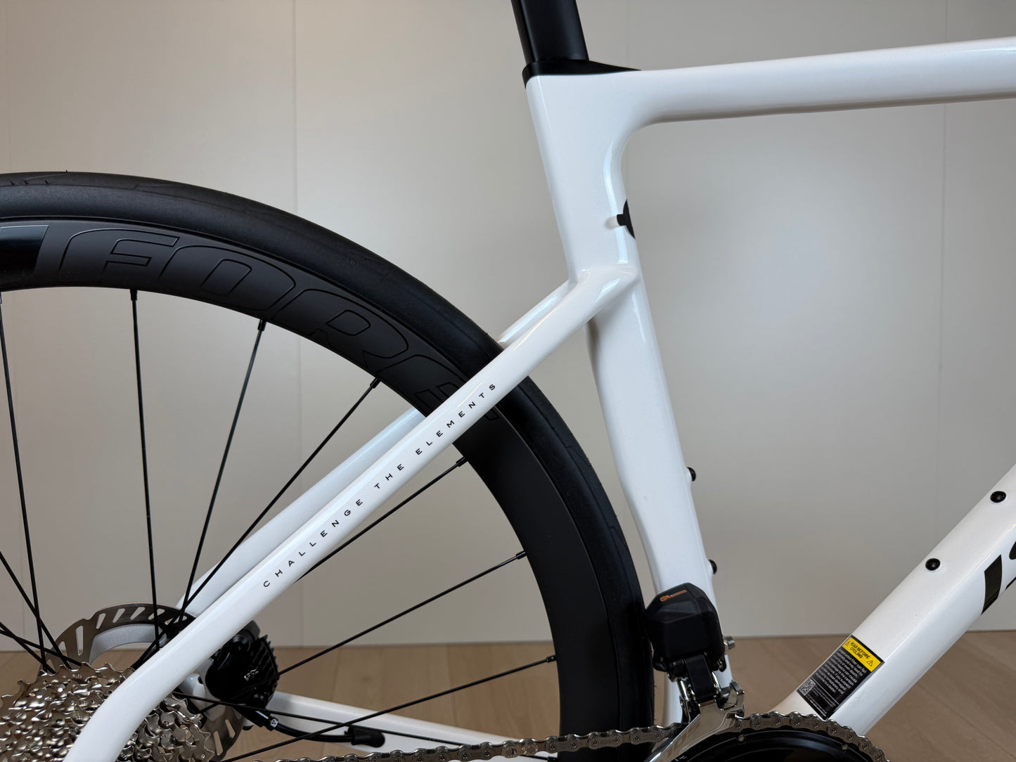 Witte Isaac Boson Mineral White 2026 M racefiets van Vélo Studio, close-up van het frame en wiel op de afbeelding.