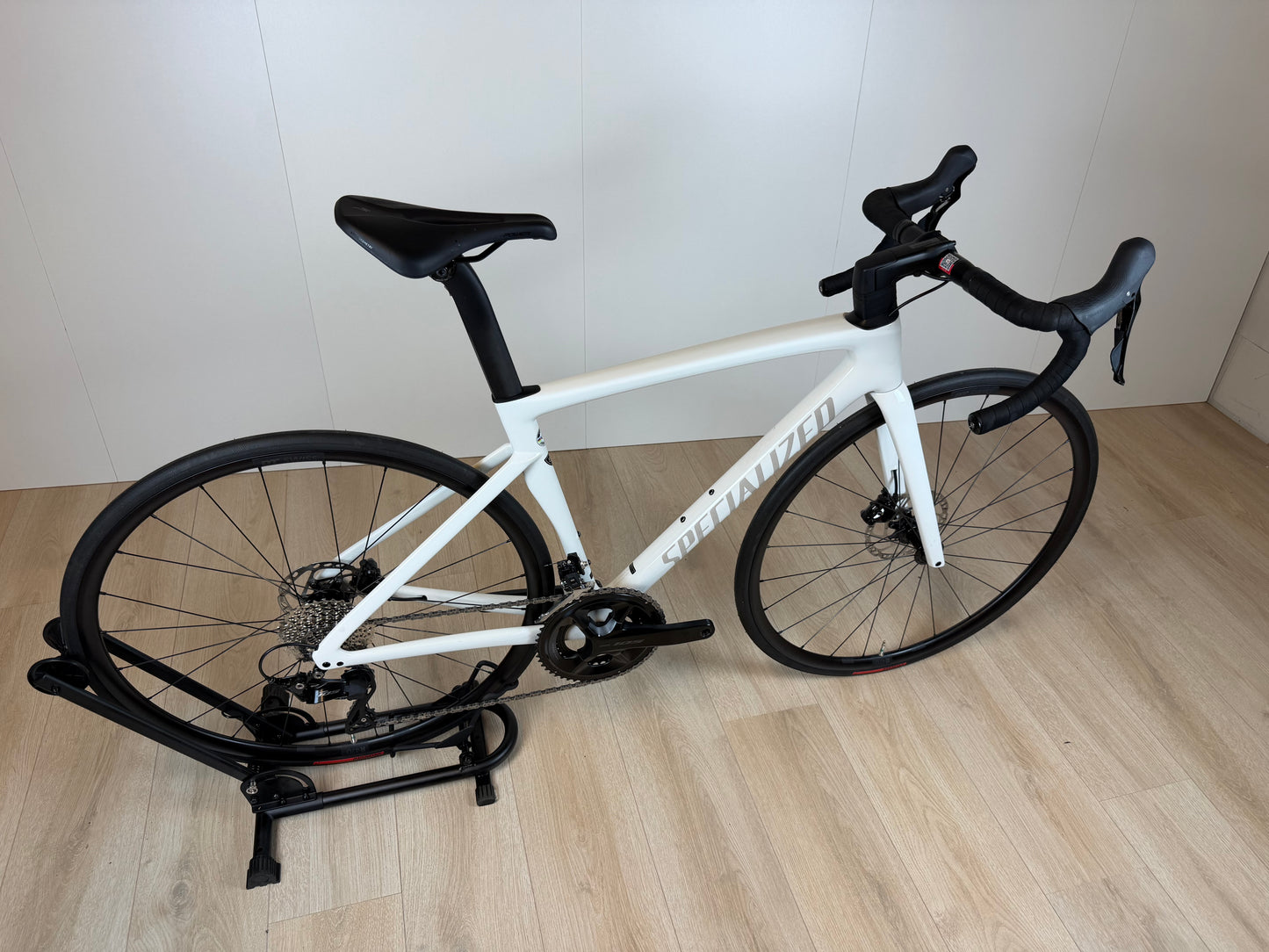 Racefiets Specialized Tarmac SL7 Sport in zwart en geel met aerodynamisch frame en racewielen, geplaatst op een weg.