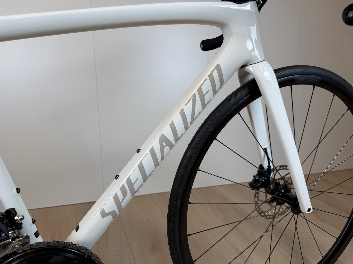 Fietsfoto van de Specialized Tarmac SL7 Sport racefiets met aerodynamisch frame en zwarte afwerking, door Vélo Studio.