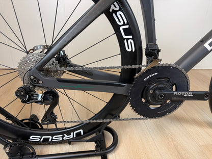 Zwart De Rosa Settanta 70 racefiets met aerodynamisch frame en dunne banden, geparkeerd op straat.