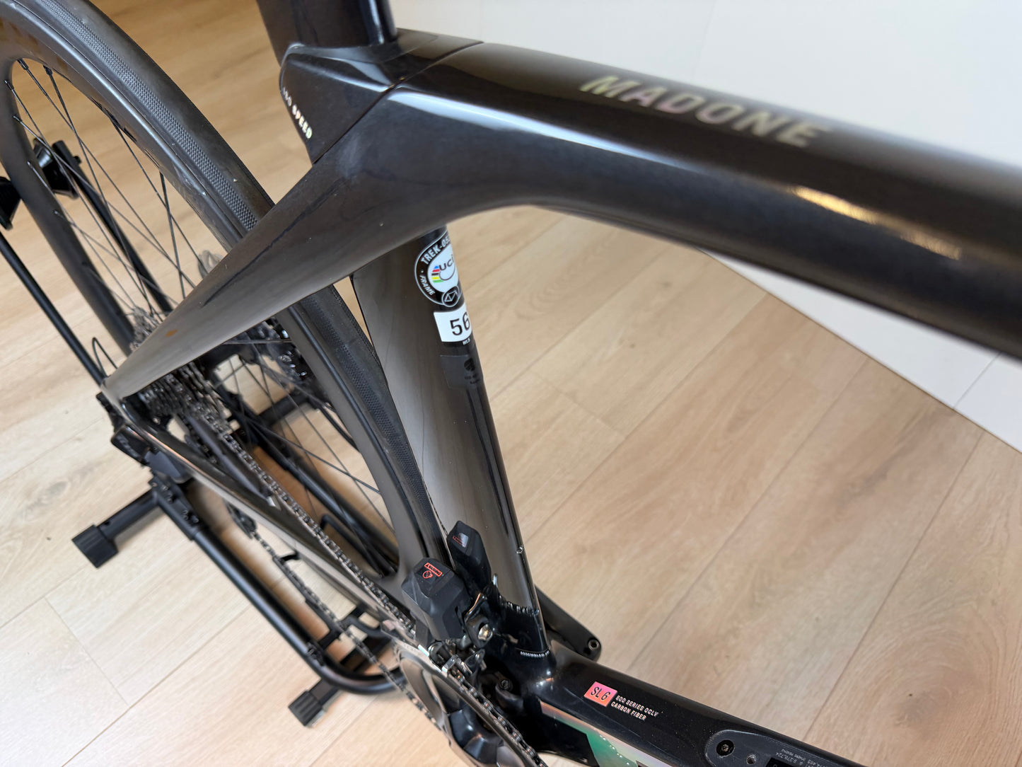 Zwart Trek Madone SL 6 racefiets met aerodynamisch frame en dunne banden, klaar voor snelle ritten.