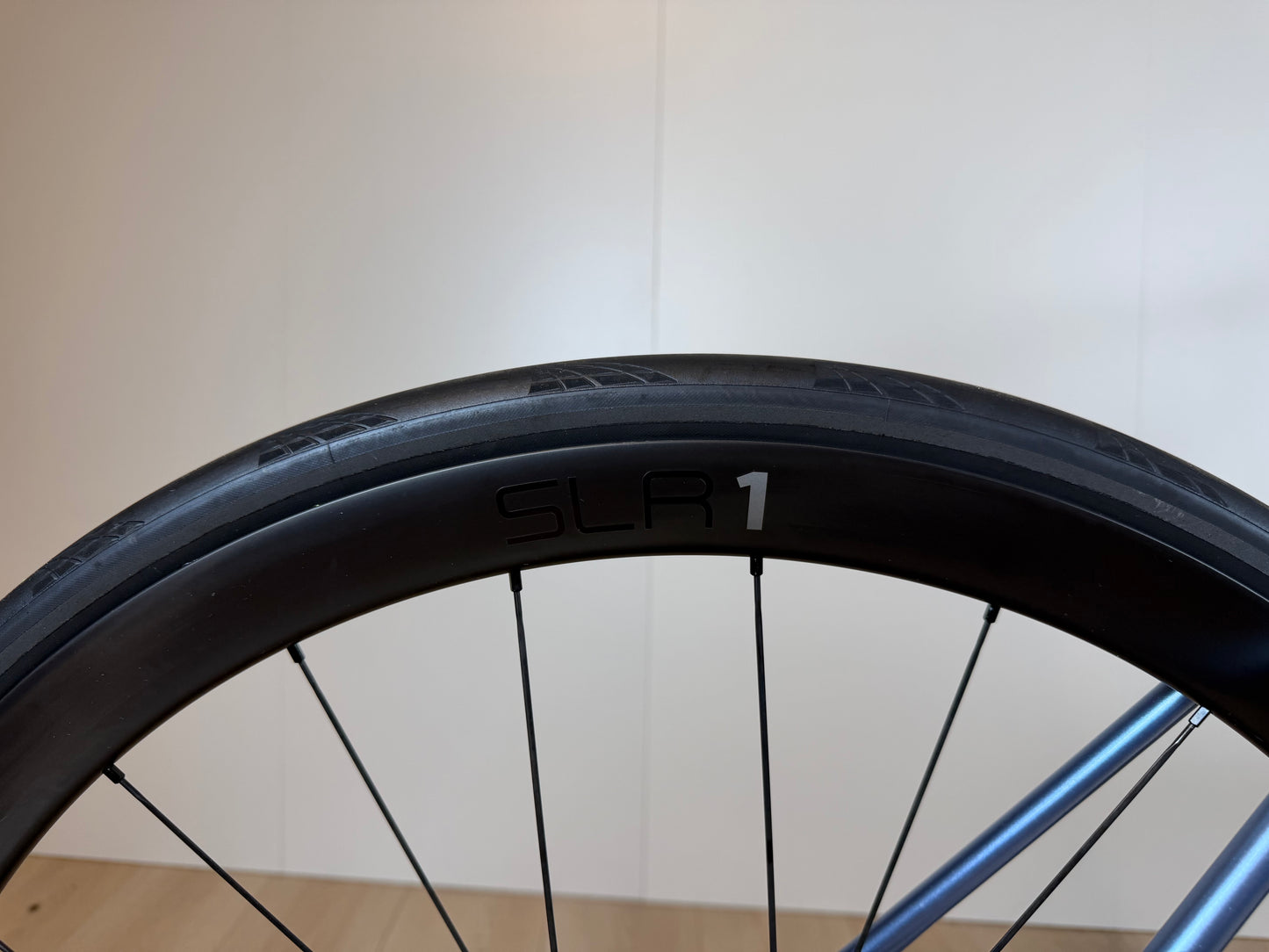 Zwart Giant TCR Advanced 0 racefiets met aerodynamisch frame en dunne banden, liggend op de vloer in een fietswinkel.