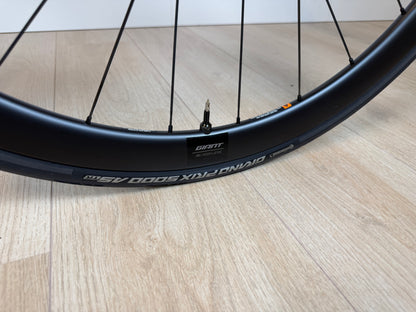 Zwart Giant TCR Advanced 0 racefiets met aerodynamisch frame en dunne banden, geplaatst op een weg.