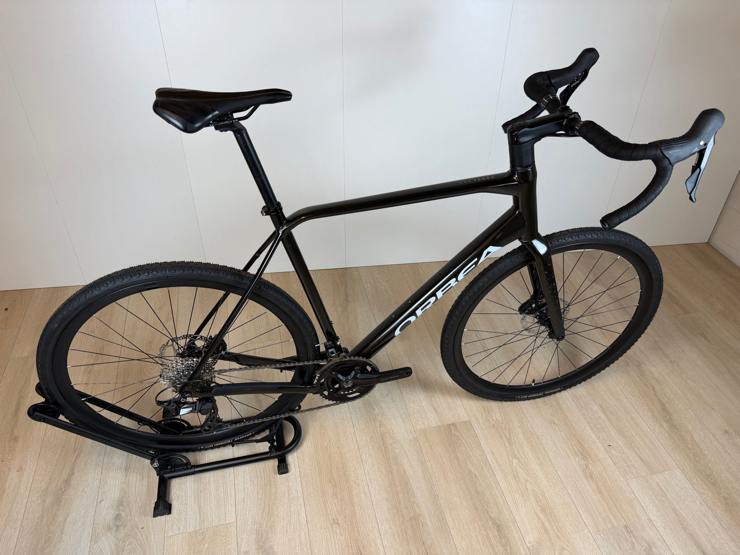Orbea Terra H30 gravelbike met zwarte frame en blauwe accenten, zichtbaar in close-up afbeelding.