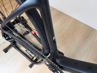 Zwarte Cervélo Aspero Apex 1 Carbon gravelbike met brede banden en aerodynamisch frame, geschikt voor off-road en gravelritten.
