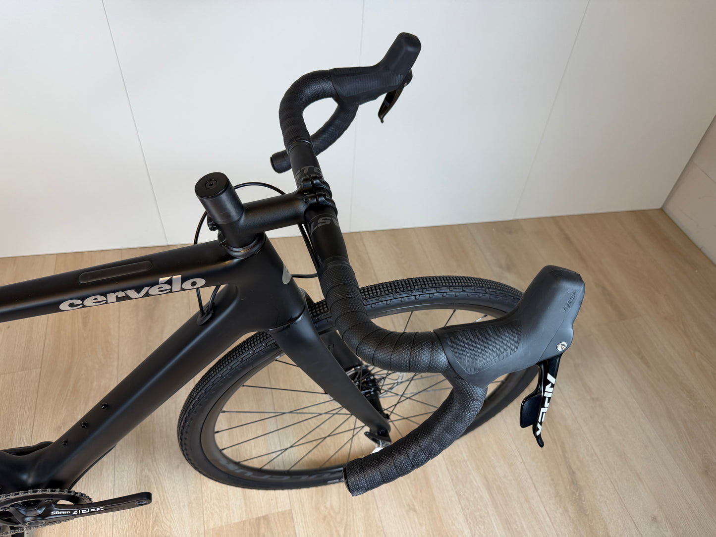 Cervélo Aspero Apex 1 Carbon Gravel fiets met zwarte frame en brede banden, klaar voor off-road avonturen