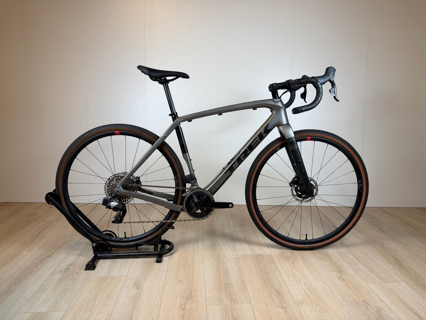 Lichte Trek Checkpoint SL 5 gravelbike met zwart frame, brede banden en geavanceerde vering, geplaatst op een weg.