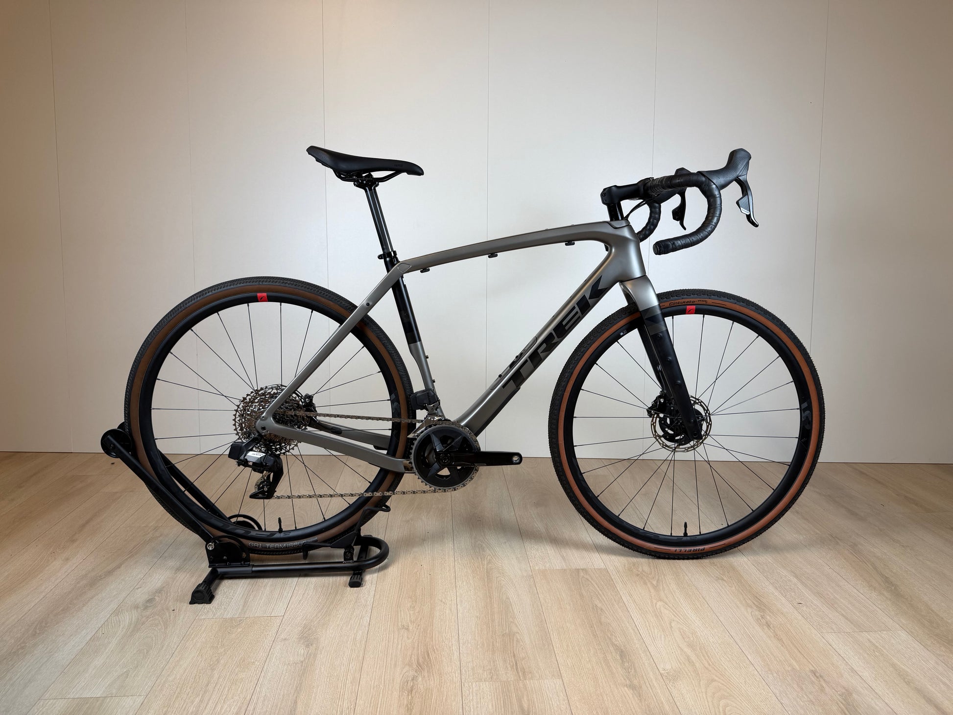 Lichte Trek Checkpoint SL 5 gravelbike met zwart frame, brede banden en geavanceerde vering, geplaatst op een weg.