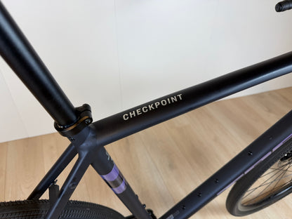 Fiets van de Trek Checkpoint ALR 4 van Vélo Studio, close-up van het frame en de wielconfiguratie op een weg.
