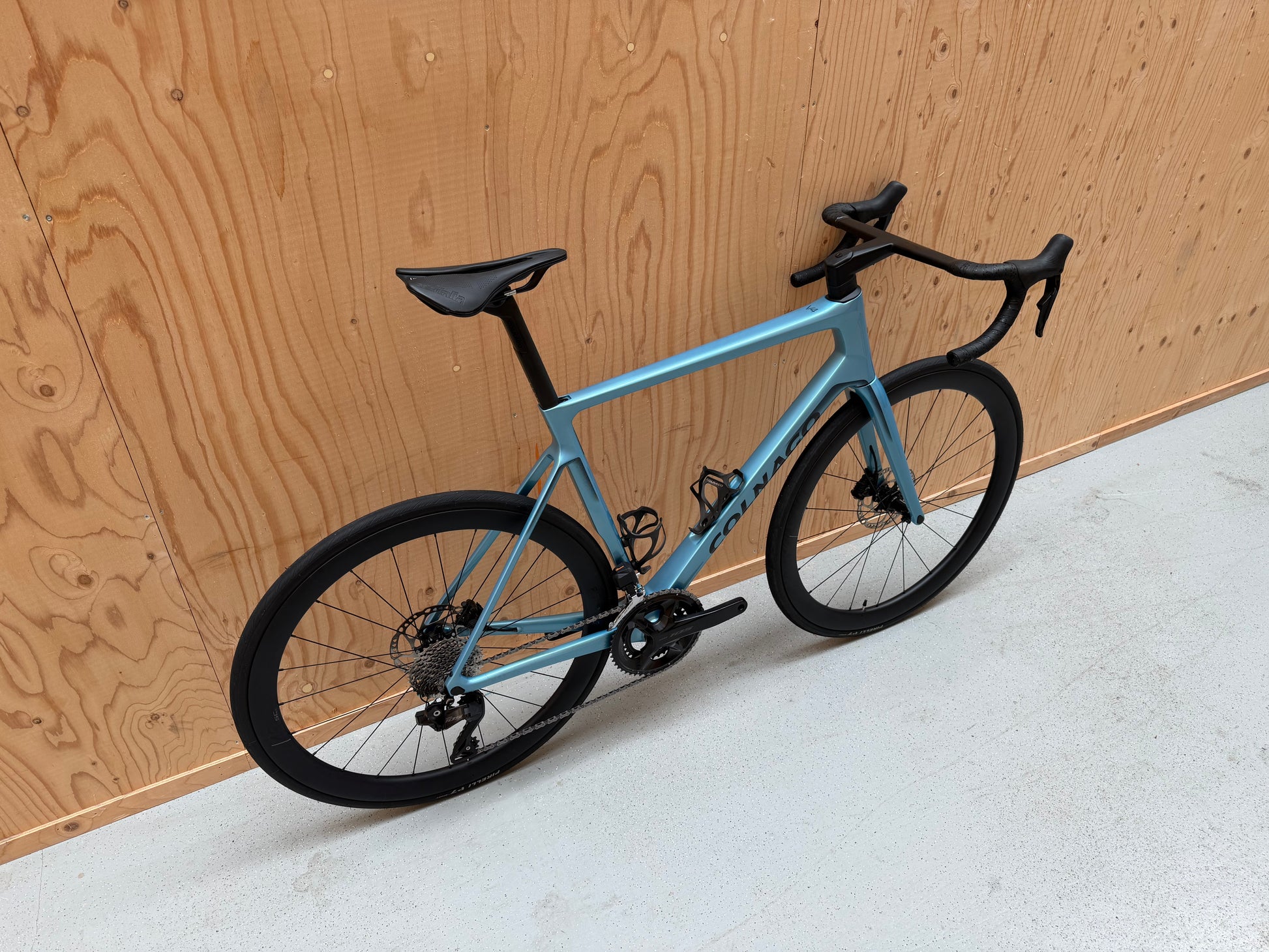 Zwart Colnago V4 racefiets met Shimano 105 Di2 elektronische schakeling en aerodynamisch frame, zichtbaar in de afbeelding.