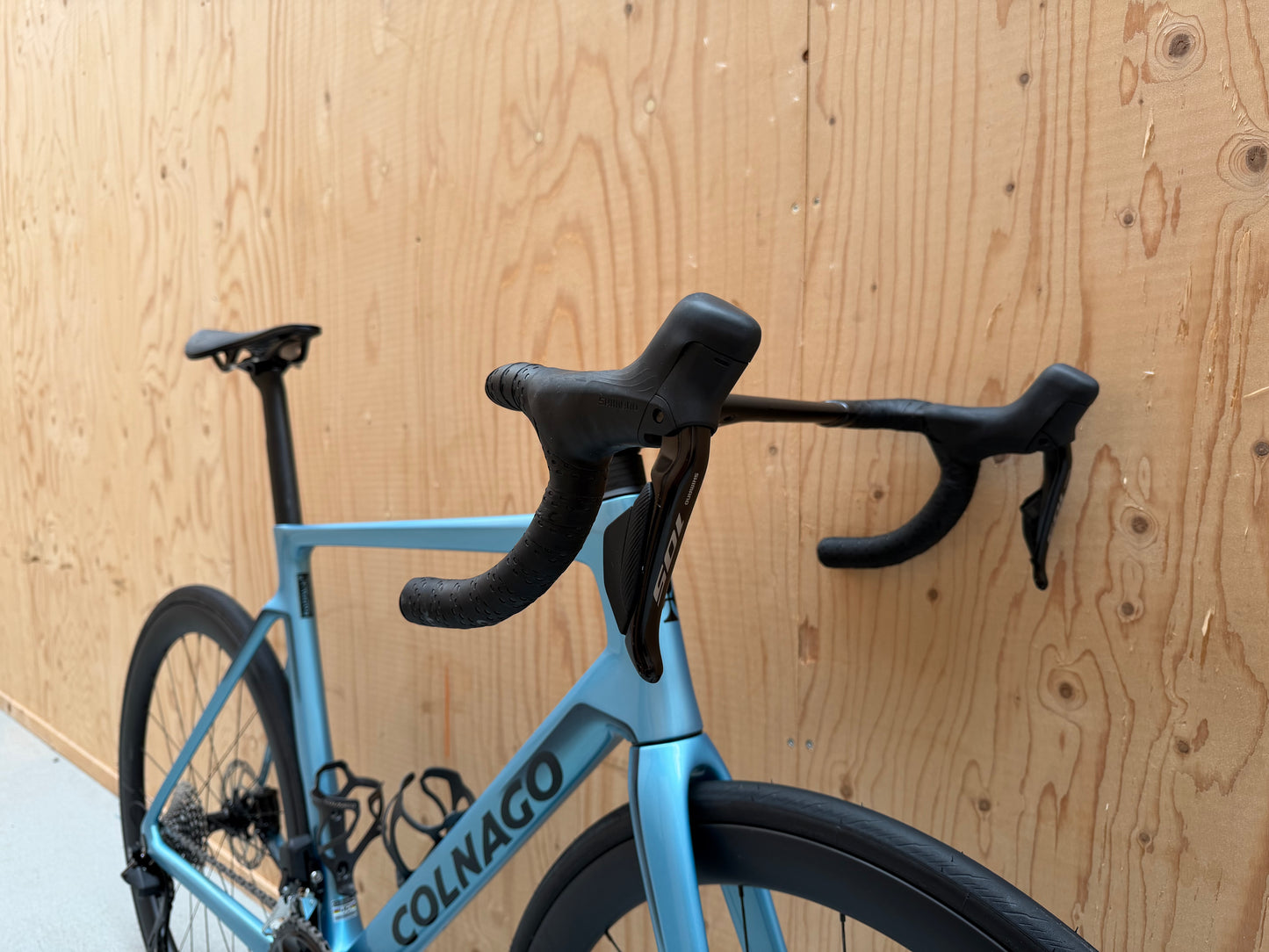 Racefiets van het merk Colnago V4 met Shimano 105 Di2 elektronische schakeling, zwart met rode accenten, close-up van frame en componenten