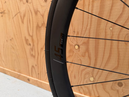 Zwart Colnago V4 racefiets met Shimano 105 Di2 elektronische schakeling, close-up van het frame en wiel.