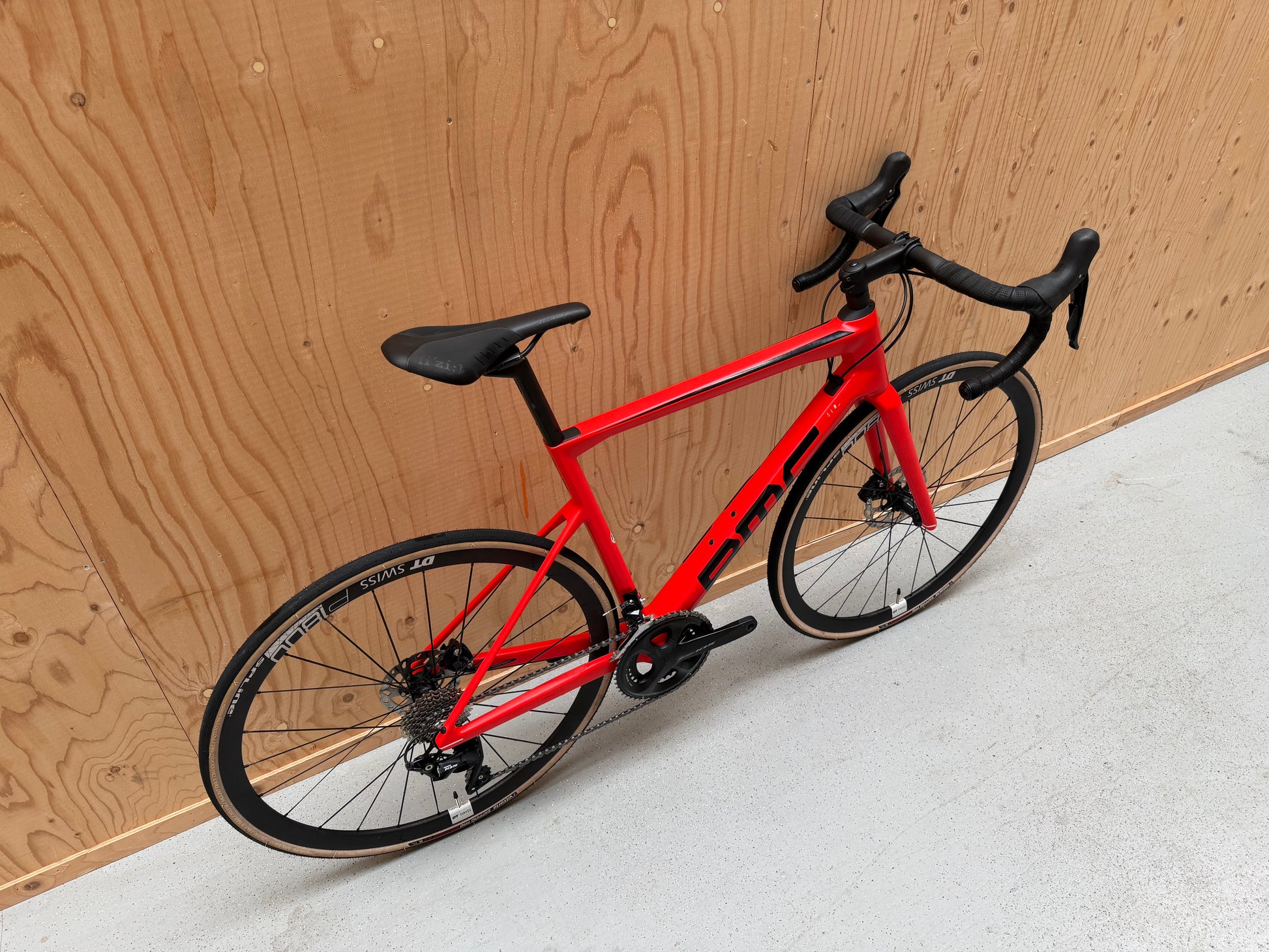 Gecombineerde foto van de BMC Teammachine SLR FIVE wielrenfiets, zwart met blauwe accenten, zichtbaar van de zijkant.
