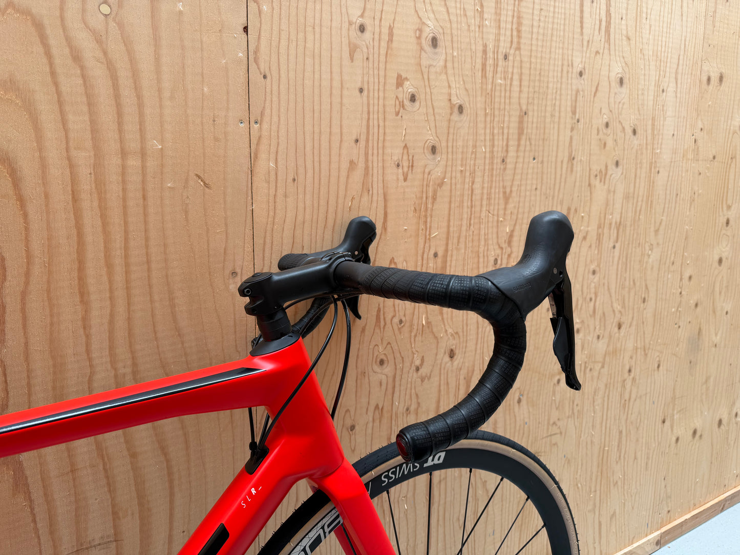 Zwarte BMC Teammachine SLR FIVE racefiets met aerodynamisch frame en blauwe accenten, klaar voor snelheid en prestaties.