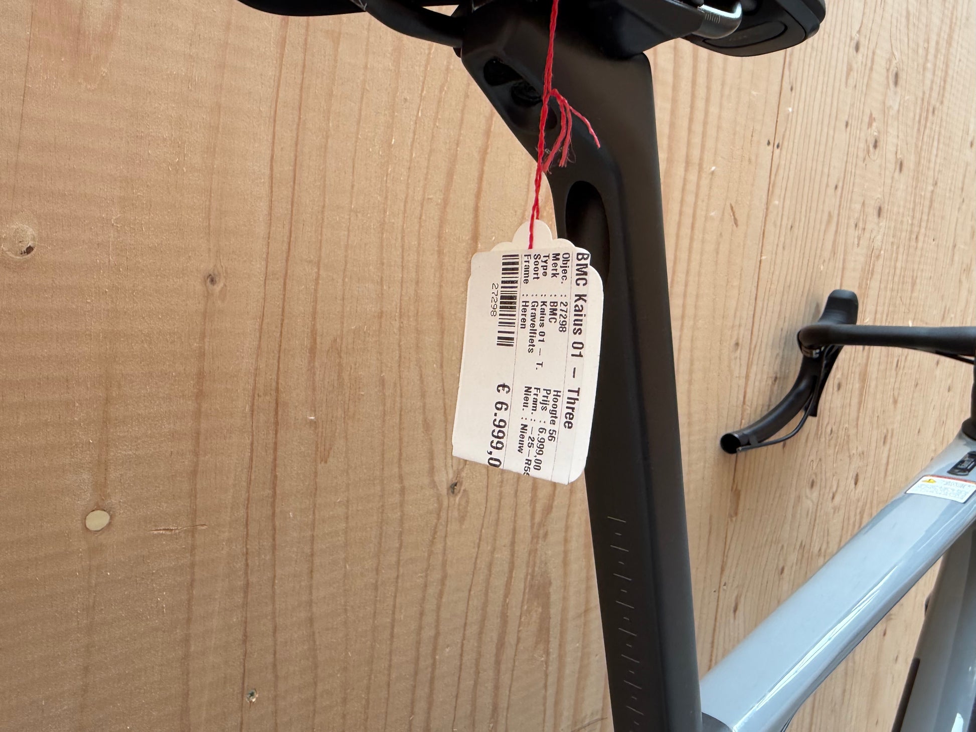 Fietsfoto van de BMC Kaius 01 Three 2026 van Velostudio, zwart met blauwe accenten en aerodynamisch frame, klaar voor gebruik