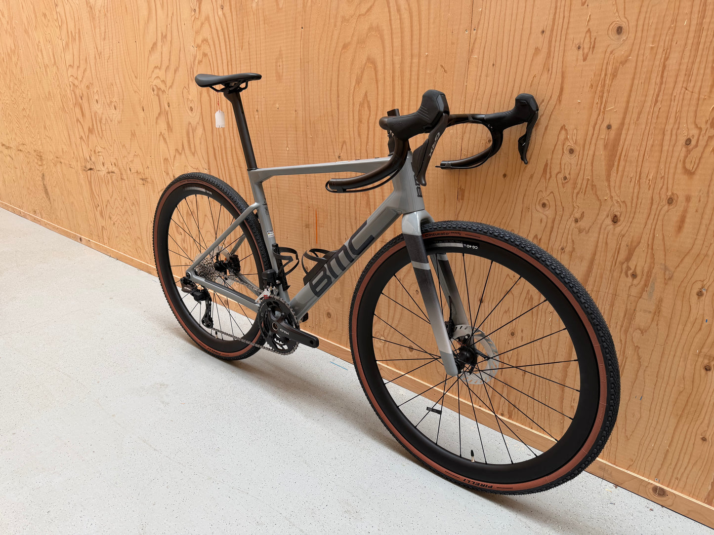 Fietsfoto van de BMC Kaius 01 Three 2026 mountainbike met zwart frame en oranje details, zichtbaar in de afbeelding.
