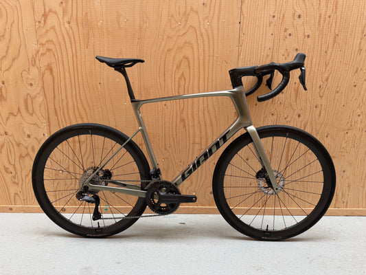 Giant Defy Advanced SL 1 racefiets van Velostudio, zwart met blauwe accenten, frame en fietsonderdelen zichtbaar