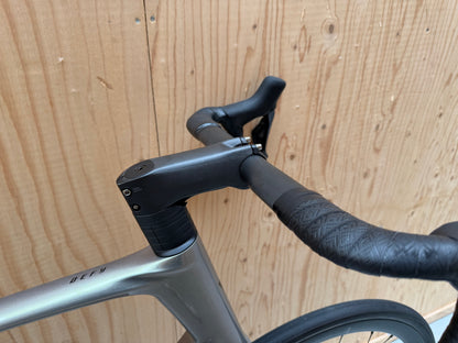 Zilveren Giant Defy Advanced SL 1 racefiets met aero frame en dunne banden, geschikt voor lange ritten en prestatiegericht fietsen.
