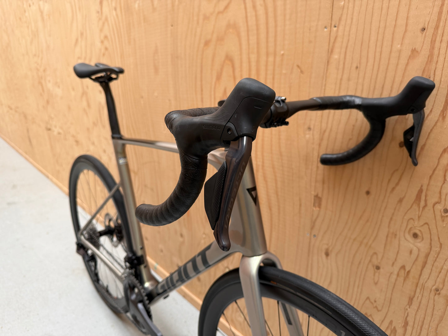 Giant Defy Advanced SL 1 racefiets van Velostudio, zwart met blauwe accenten, frame en wielset zichtbaar op de foto.