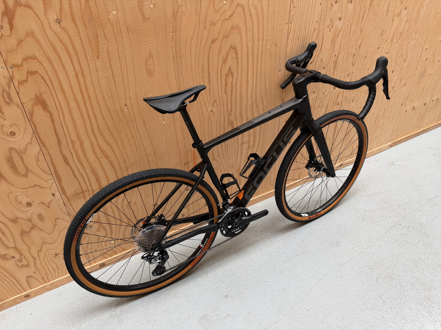 Focus Atlas 8.7 fietsslot van Velostudio, stevig en veilig met ketting en slot, zwart kleur, ligt op een houten tafel.