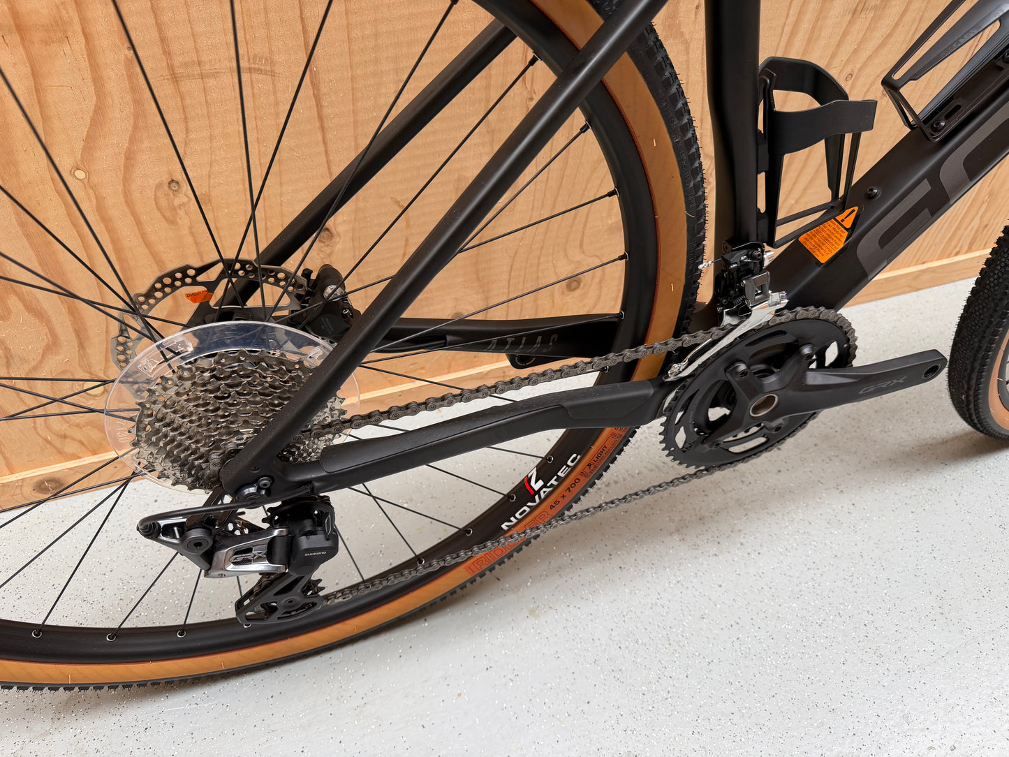 Focus Atlas 8.7 fiets van Velostudio, zijaanzicht met zwart frame en blauwe accenten, klaar voor gebruik