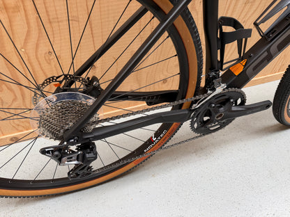Focus Atlas 8.7 fiets van Velostudio, zijaanzicht met zwart frame en blauwe accenten, klaar voor gebruik