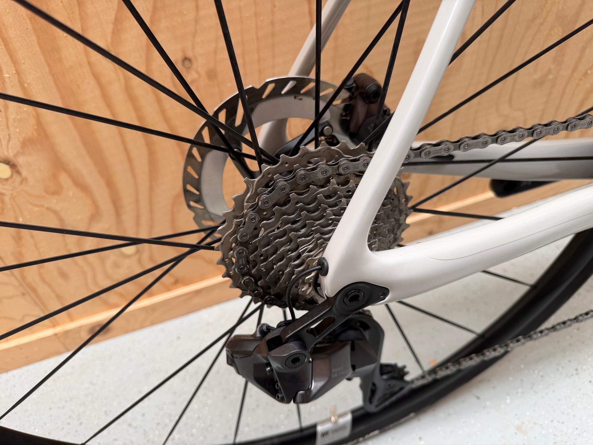 Stevens Izoard PRO Disc wielrenfiets met zwarte frame en schijfremmen, close-up van het fietsframe en wiel.