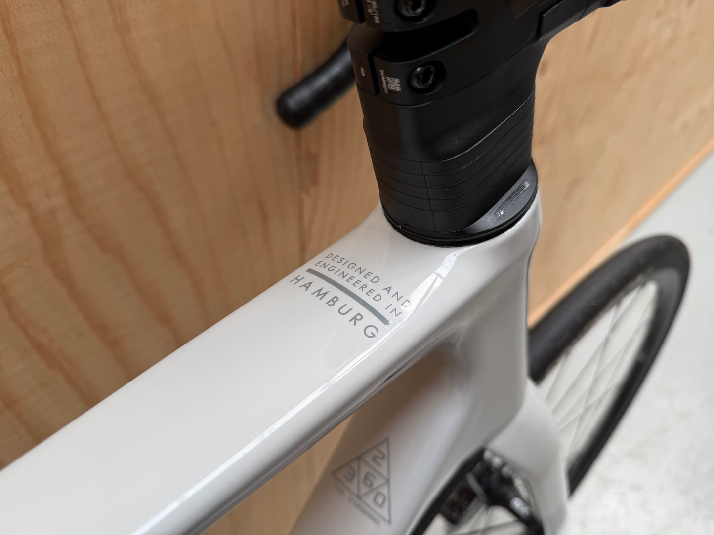 Stevens Izoard PRO Disc wielrenfiets met zwarte frame en schijfremmen, close-up van het voorwiel en framemerk op de fiets